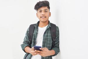 joven indio usando un teléfono inteligente con fondo blanco. foto