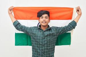 Young indian man holding indian national flag in hand over white background photo