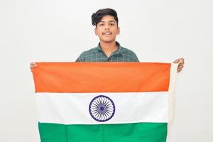 joven indio sosteniendo la bandera nacional india en la mano sobre fondo blanco foto