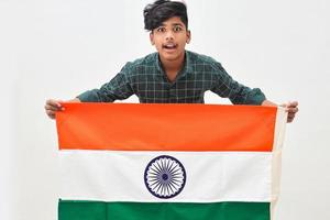 joven indio sosteniendo la bandera nacional india en la mano sobre fondo blanco foto