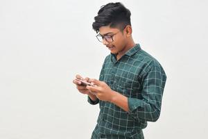 joven indio usando un teléfono inteligente con fondo blanco. foto