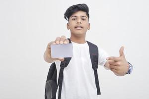 estudiante universitario indio que muestra la tarjeta sobre fondo blanco. foto