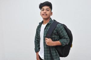 Handsome Indian collage boy standing on white background. photo