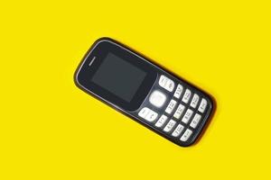 vintage mobile phone with copyspace on yellow background. photo