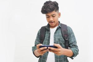 Indian college student using smartphone on white background. photo