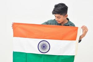 joven indio sosteniendo la bandera nacional india en la mano sobre fondo blanco foto