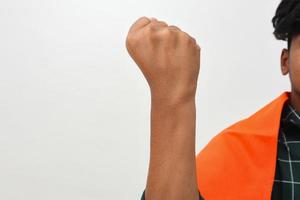 Close up of hand of young caucasian man over isolated background doing protest and revolution gesture, fist expressing force and power photo