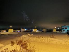 fuegos artificiales de año nuevo en el pueblo de cabañas en una noche de invierno foto