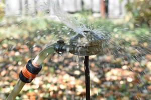 Water fountain from a sprinkler in the garden photo