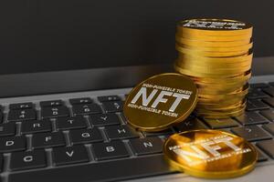 NFT coins stacked on top of a laptop keyboard photo