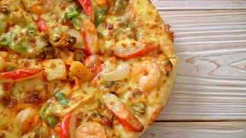 Meeresfrüchte - Garnelen, Tintenfisch, Muscheln und Krabben - Pizza auf Holztablett