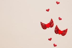 concepto de día de san valentín dos corazones rojos con alas vista superior con espacio de copia foto