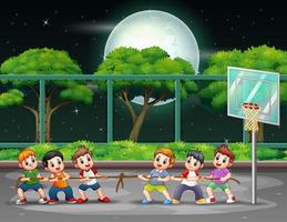 Group of boys playing tug of war on the court at night vector