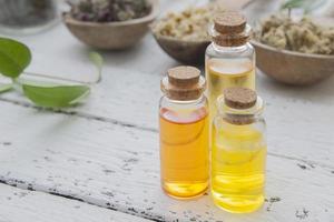 Essences in vintage glass bottles with dry herbs on a wooden table. Alternative medicine concept. Copy space photo