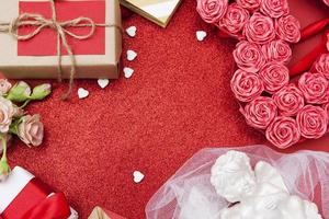 Red glitter background with hearts, gifts, flowers. Free space for Valentines Day greeting text