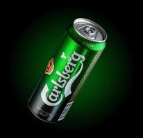 almaty, kazajstán 11 de octubre de 2019 lata de cerveza carlsberg en un fondo verde con iluminación. publicidad de una marca de cerveza foto