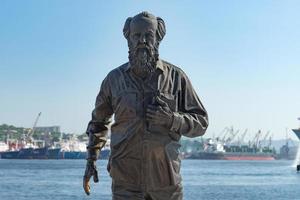 Vladivostok, Russia-July 28, 2018- The monument to Solzhenitsyn against the background of sea and ships.
