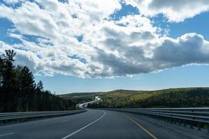 A landscape with a winding highway under a cloudy sky. photo