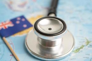 Black stethoscope with New Zealand flag on world map background, Business and finance concept. photo