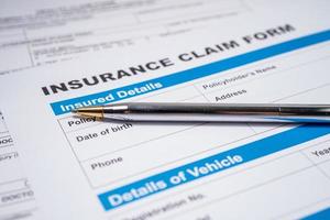 Pen on Insurance claim accident car form, Car loan, insurance and leasing time concepts. photo