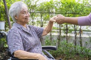 Holding hands Asian senior or elderly old lady woman patient with love, care, encourage and empathy at park. photo