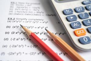 Pencil and calculator on mathematic formula exercise test paper in education school. photo