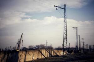 Deserted area with ugly buildings and electricity transmission pylons. photo