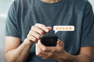 Close up of man customer giving a five star rating on smartphone. Review, Service rating, satisfaction, Customer service experience and satisfaction survey concept. photo