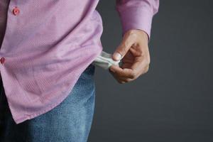 young man shows empty pant pocket with copy space photo