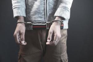 man's hand with handcuff on black background. photo