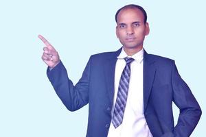 Young smiling Indian businessman pointing with finger upward image photo