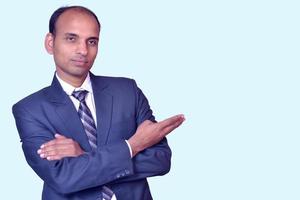 Young smiling Indian businessman pointing with finger upward image photo