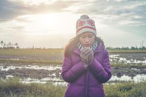 mujer joven estaba jugando en un campo de flores en el aire de invierno. foto