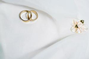 dos anillos de boda sobre el vestido de novia foto