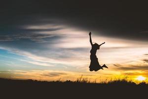 Silhouette of a beautiful girl jumping photo
