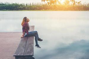 Young beautiful hipster woman sitting on the lake pier ,Relaxed atmosphere, summer.