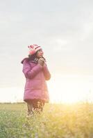 Young woman was playing in a field of flowers in the winter air. photo