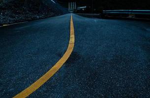 Asphalt road with yellow line curve. Black and yellow asphalt road, Road curve, Road Background, angle, highway, material. Curved Road With Yellow Line. photo