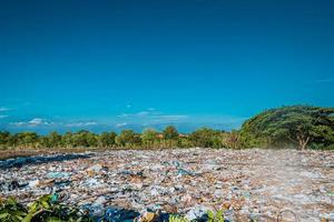 depositario de basura tierra vertedero de basura ambiental. vertido de basura en la tierra área de bosque sucio. foto