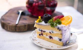 Close up Slice birthday fruit cake in plate violet delicious cream in layer