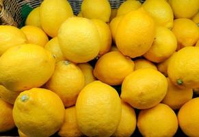 colorido de exhibición amarilla de limones en una canasta en bio mercado o tienda de comestibles. fondo de limones frescos orgánicos de cerca. limones frescos saludable vitamina c fruta