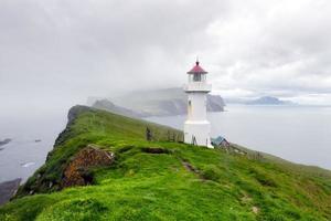 Foggy view of old lighthouse on the Mykines island