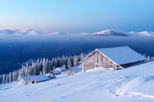 Snowy cabin in the winter mountains photo