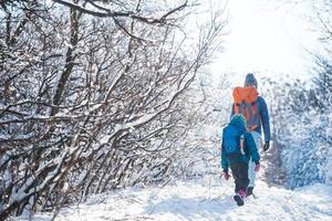 Woman with a child on a winter hike in the mountains. photo