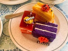 Various colored cakes on plates. Sweet desserts. Studio Photo