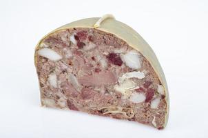 Chunk of meat product saltison. Pork homemade headcheese on wooden board. Delicious snack. Studio Photo