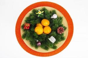 Christmas wreath with tangerines and plate. Studio Photo