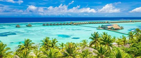 asombroso atolón e isla en maldivas desde vista aérea. tranquilo paisaje tropical y paisaje marino con palmeras en la playa de arena blanca, naturaleza pacífica en la isla de resort de lujo. estado de ánimo de vacaciones de verano foto
