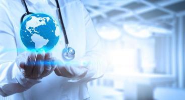 Medical Doctor holding a world globe in his hands as medical network concept photo