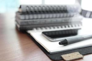 Office workplace with laptop and smart phone and stylus on wood table photo